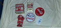 All five Coca-Cola tins laid out