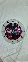 Round Coca-Cola wall clock showing bottle and 5¢ graphic