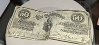 Obverse of Confederate $50 note showing design, folds and wear
