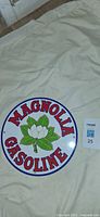 Front of Magnolia Gasoline sign showing graphics and text