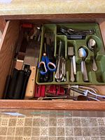 Open drawer showing full assortment of utensils and flatware