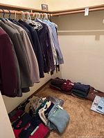 Overall closet view showing jackets, shirts, folded sweaters