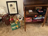 Group view showing stuffed animals, stool, framed picture, plaque, suitcase, and cabinet shelves of games