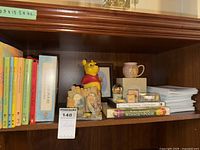 Shelf with books, ceramic figurines, mug and framed print