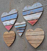 Front view showing five wooden heart plaques with distressed paint