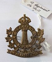 Front view of brass cap badge with tag