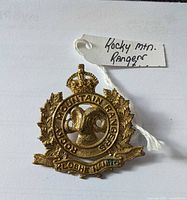 Front view of brass WW2 Rocky Mountain Rangers cap badge