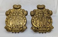 Front view of both brass PWOR cap badges
