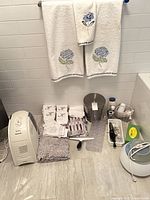 Overall lot showing towels, humidifiers, hairdryer, waste bin