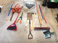 Overhead layout of all garden tools, broom, shovels, axe, rake, dustpan and brush head