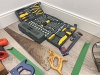 Full lot including open green mechanics tool set, crosscut saw, red drill, adjustable wrench, hacksaw frame and guides