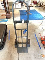 Front view of steel hand truck showing loop handle, nose plate and wheels