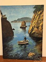 Full view of unframed oil painting showing coastal scene and rowboat