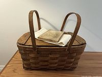Basket closed with book and towel resting on lid