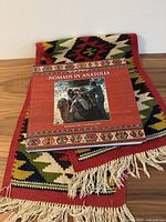 Book atop table runner showing cover graphics and fringe detail