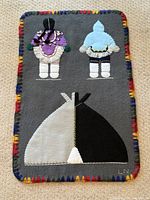 Full view of felt wall hanging showing figures, igloo, border
