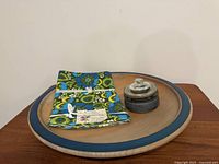 Platter holding folded tablecloth and lidded jar