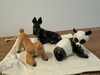 Group shot of three Lomonosov porcelain animal figurines and canvas bag