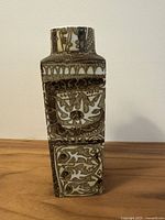 Front view of square faience vase showing stylised motifs