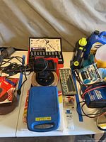 Overview of lot showing polisher, socket set, stud puller case, work light, automotive fluids and accessories