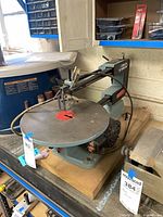 Front left view of Delta 16" scroll saw on bench showing overall condition