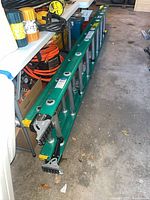 Full view of collapsed Werner fiberglass extension ladder on garage floor