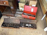 overview of three metal toolboxes on pallet, showing sockets and wrenches