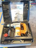 Rotary hammer in case with manual and accessories visible