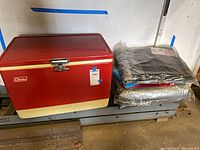 Cooler closed with tarps and blanket stacked beside