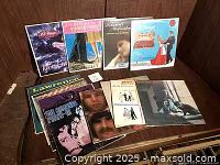 Group shot of approximately 13 LPs on table showing front and back rows of sleeves