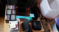 Overall lot view with cassettes, racks, CDs, wallets, StarTech adapter