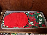 Sterilite tub with red quilted placemat and folded green poinsettia linens
