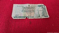 Front of RBS £1 note showing portrait, denomination and serial A72 321362, heavy wear, edge tear