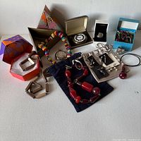 Entire lot overview with necklaces, rings, watch, earrings, hair clips, boxes and pouches visible