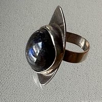 Angled view of ring showing labradorite cabochon and leaf-shaped bezel