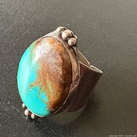 Ring angled view showing turquoise cabochon and bead accents