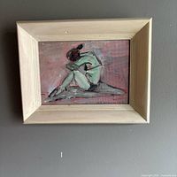 Front view of framed oil painting depicting seated girl, signature visible