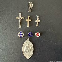 Full lot view with figurine, three crosses, three small pins and oval medal