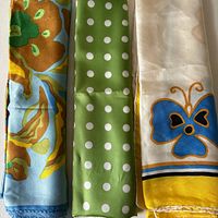 Three silk scarves laid side by side showing patterns and colors