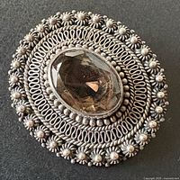 front view showing filigree design and faceted amethyst