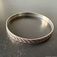 Full view of sterling silver bangle showing scroll design