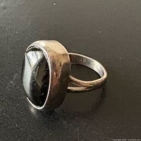 Angled view of sterling silver ring showing onyx cabochon and bezel setting