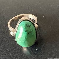 Front view of sterling silver ring with green turquoise cabochon