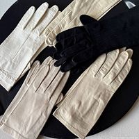 All three pairs of gloves laid out: black long, white, beige