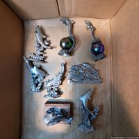 All seven pewter-look dolphin pieces inside box