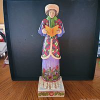 Front view of Jim Shore woman caroler figurine