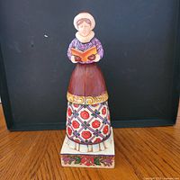 Front view of girl caroler figurine on square base
