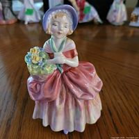 Front view of Royal Doulton Cissie figurine showing dress, bonnet and basket