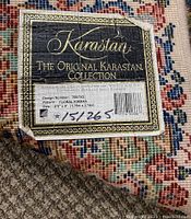 Close-up of Karastan label showing Original Collection, pattern 700/742, size 5'9" x 9' and wool content