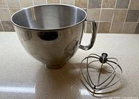 Stainless steel bowl and wire whip side by side